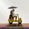 Romantic Couple Riding Yellow Scooter Statue - A Symbol of Love and Adventure